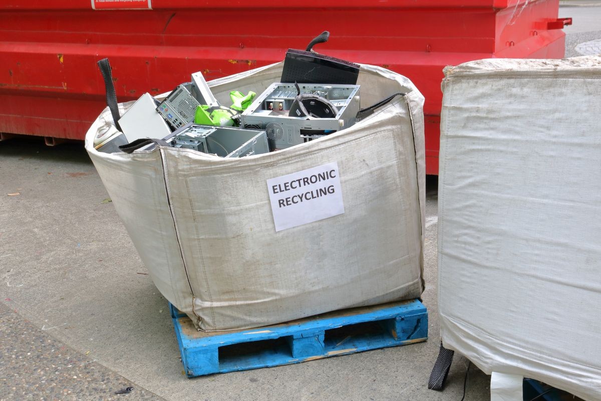 A large bag filled with computer parts and components is left on the street corner where it will be picked up and recycled. 